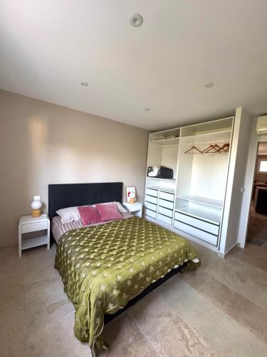 a bedroom with a bed with a green bedspread at SUPERBE T2 moderne - ENTREE DE VILLE - PARKING PRIVE in Ajaccio