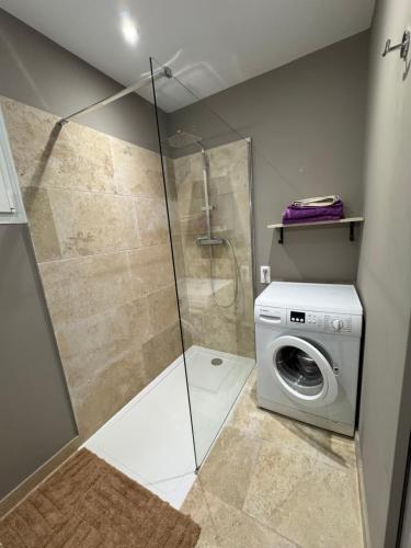 a bathroom with a shower and a washing machine at SUPERBE T2 moderne - ENTREE DE VILLE - PARKING PRIVE in Ajaccio