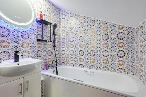 a bathroom with a bath tub and a sink at Reeha's Hotel Apartments in Southend-on-Sea