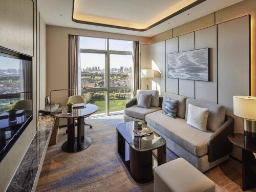 a living room with a couch and a table at Pullman Suzhou Taicang in Taicang