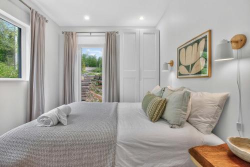 a bedroom with a large white bed with a window at La Trêve Mont Tremblant in La Conception