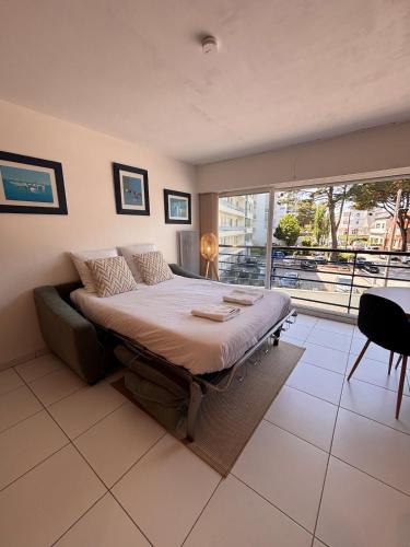 a bedroom with a bed and a large window at Ti Gon - Le Cabanon Baulois in La Baule