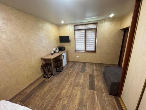 a room with a desk and a table in a room at Тихий дворик in Odesa