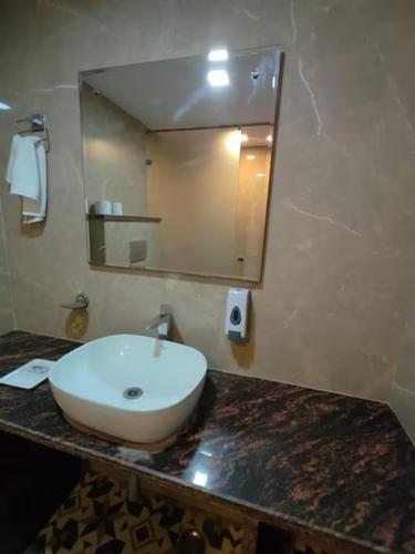 a bathroom with a sink and a mirror on a counter at Hotel Maurya Heritage In Karol Bagh in New Delhi