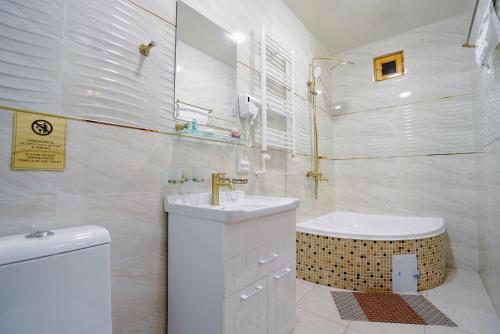 a white bathroom with a sink and a toilet at Khalid Boutique in Bukhara