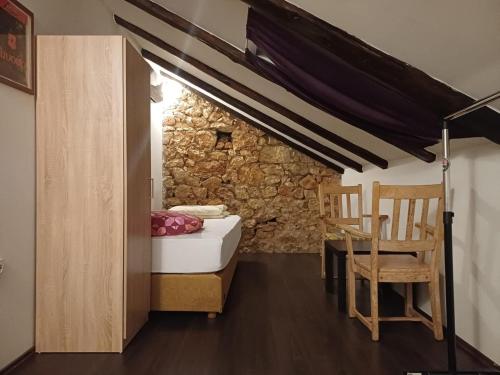 a room with a bed and a table and chairs at Hostel Old School in Rijeka