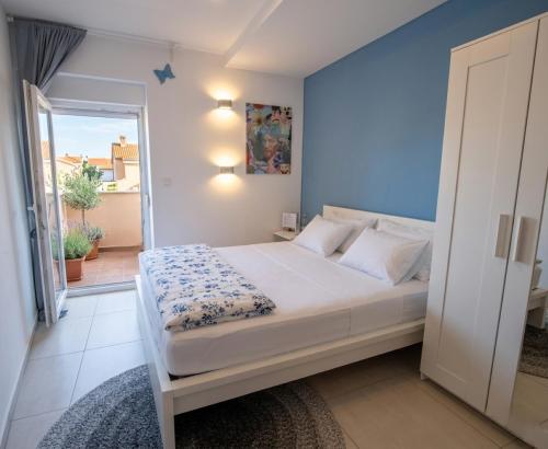 a bedroom with a bed and a door to a balcony at Paradise for children, Family apartment Oros Medulin, with a pool, gd in Medulin