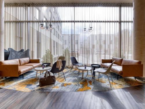 a living room with couches and chairs and a table at ibis Styles Coburg in Coburg