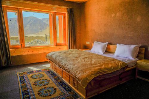 a bedroom with a bed with a view of a mountain at Eco Residence Pangong in Lukung