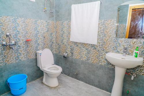 a bathroom with a toilet and a sink and a mirror at Eco Residence Pangong in Lukung