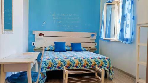 a bedroom with a bed with a blue wall at B&B Catanzaro lido La collina dei poeti in Catanzaro Lido