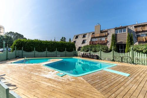a swimming pool on a wooden deck next to a building at The Perch - Spa & Pool in Beaupré