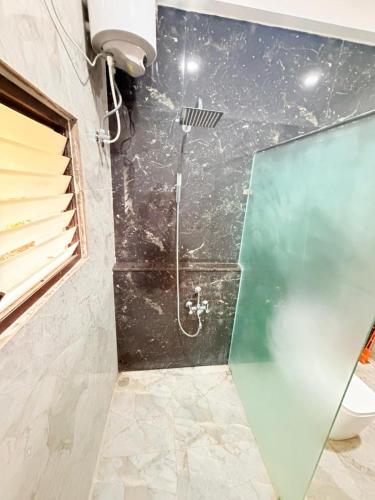a shower with a glass door in a bathroom at JayKay Resort in Pūrnānkuppam
