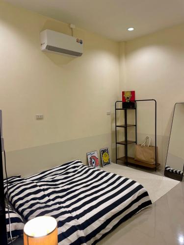 a bedroom with a black and white striped bed at Krabi Buddy House in Ban Khlong Chi Lat