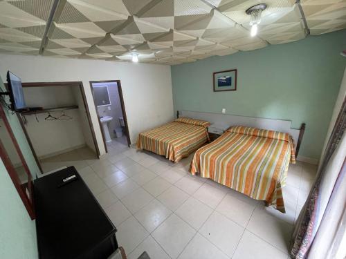 a bedroom with two beds and a tv in it at Hotel Playa Azul in Catemaco