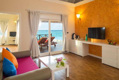 a living room with a couch and a television at Sun Siyam Vilu Reef - 24 Hours All-Inclusive with Free Transfer in Dhaalu Atoll