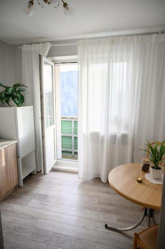 a living room with a table and a large window at Side Apartments in Rakvere
