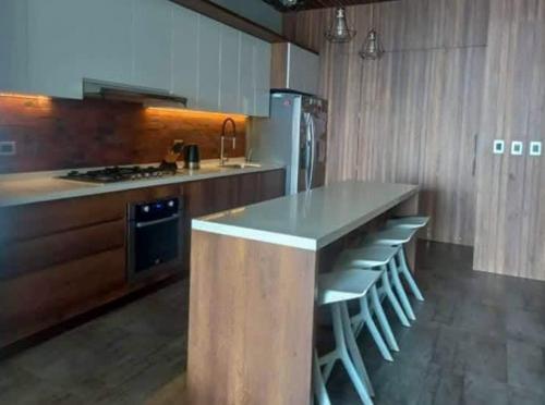 a kitchen with a counter with stools and a stove at Spacious 4BR Duplex with Pool in Punta Hermosa in Punta Hermosa