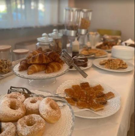 a table topped with plates of pastries and donuts at HOTEL Monte Cimone in Caldonazzo