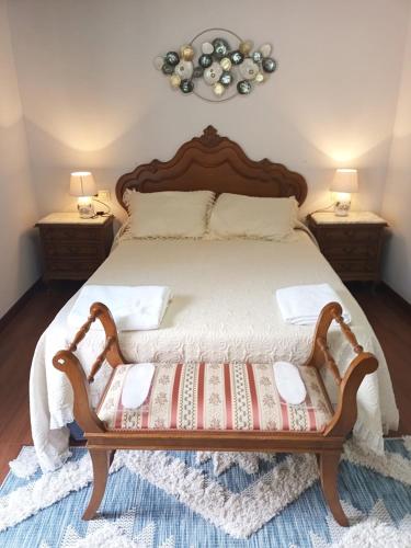 a bedroom with a wooden bed with two night stands at O Cobo Vacacional in Padrón