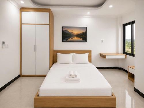 a bedroom with a bed with two slippers on it at Dreamora Serenity Hotel & Residence in Hanoi