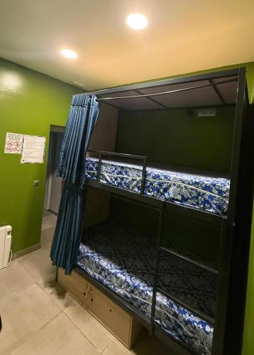 two bunk beds with blue curtains in a room at Hostel BM19 in Madrid