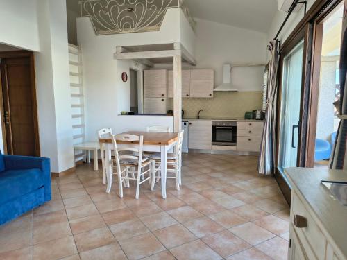 a kitchen and dining room with a table and chairs at The pool house - Il Gabbiano in Palau