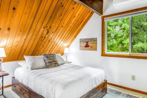 a bedroom with a bed with a wooden ceiling and a window at Alderbrook A-Frame in Union