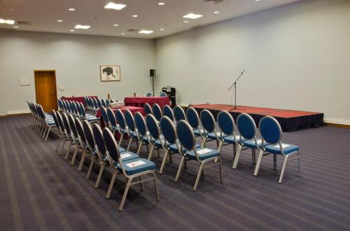 a conference room with chairs and a table and a podium at VIP Executive Santa Iria Hotel in Santa Iria da Azóia