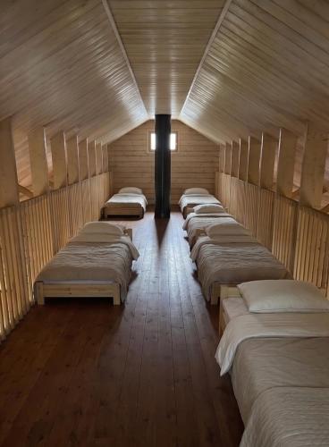 a row of beds lined up in a room at Pitkälampi Private Lake Lodge in Jokikylä
