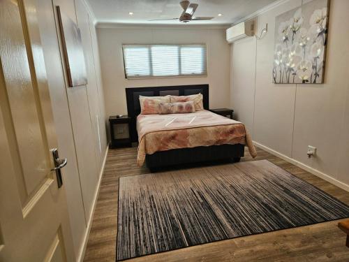a bedroom with a bed and a door and a rug at THE PONT port Edward UNIT 1 in Port Edward