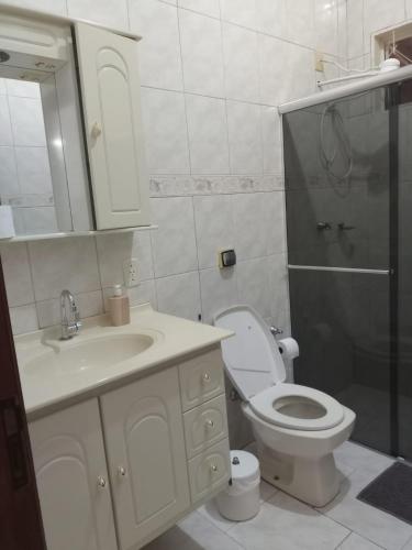 a bathroom with a toilet and a sink and a shower at Suíte Gigá 1 in Brotas