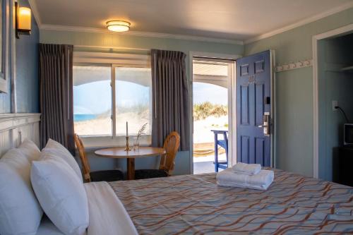 a bedroom with a bed with a view of the ocean at Colonial Inn in Nags Head