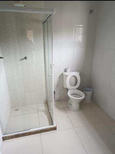 a bathroom with a toilet and a glass shower at Casa Areal in Araruama