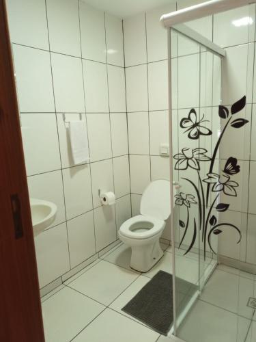 a white bathroom with a toilet and a sink at Suíte GiGá 2 in Brotas
