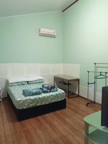 a room with a bed and a table and a desk at Suíte GiGá 2 in Brotas