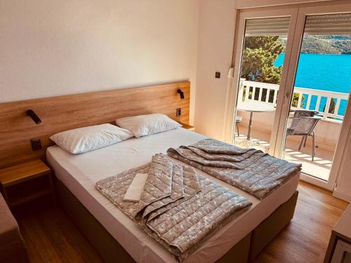 a bedroom with a bed with a view of the ocean at Apartments Kristic in Neum