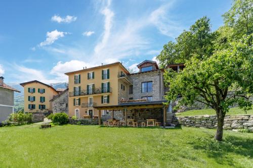 a large house with a yard with a tree at Incanto del Lago Country House in Faggeto Lario 