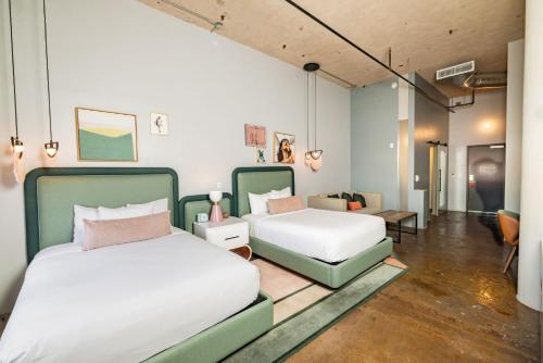 two beds and a couch in a room at Canvas Hotel Dallas in Dallas