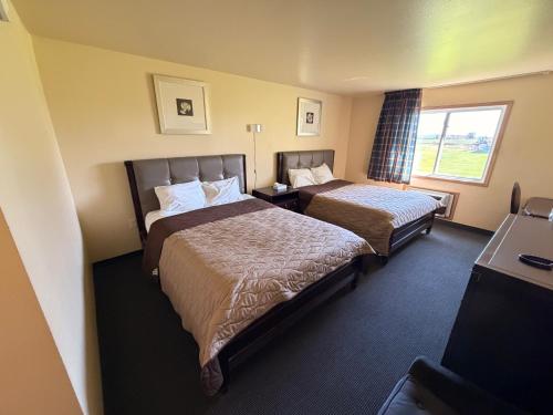 a hotel room with two beds and a window at East Grand Inn Grand Forks ND I 29 in East Grand Forks