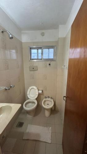 a bathroom with a toilet and a sink at Hotel Maresias in Villa Gesell