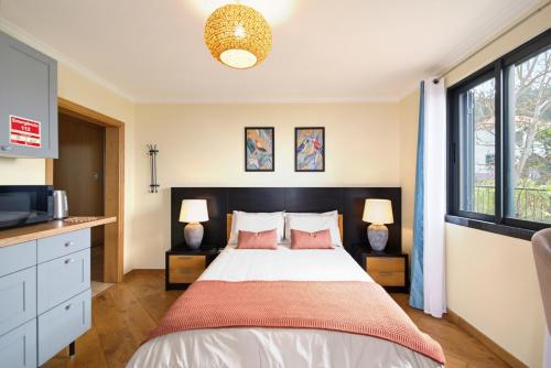 a bedroom with a large bed with two lamps at Bella Vista Studio in Canhas
