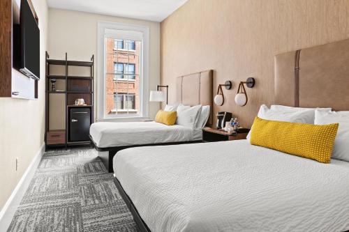 a hotel room with two beds and a television at The Wills Hotel in Cumberland