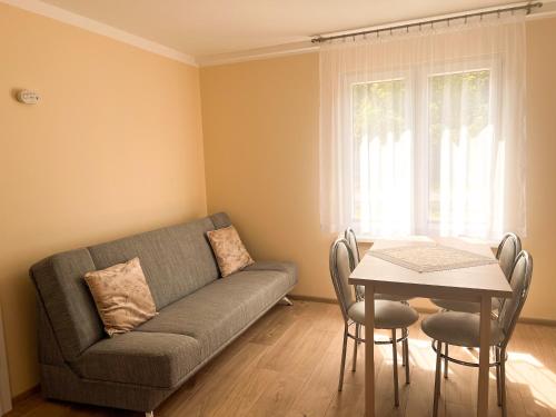 a living room with a couch and a table at Zieleniec in Drawsko