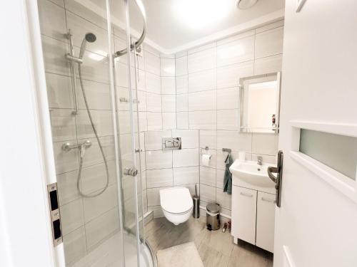 a bathroom with a shower and a toilet and a sink at Zieleniec in Drawsko