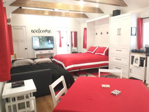 a bedroom with two beds and a television in it at Garden Guest Cottage in Harrisonburg