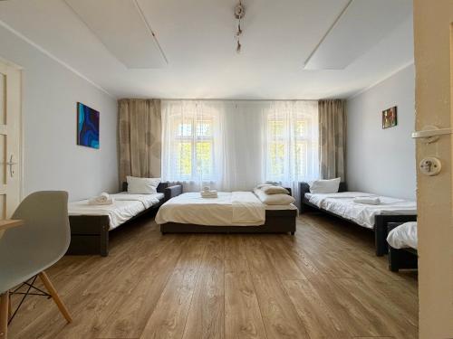 a large room with three beds in it at Park Leśnicki Homely Studios by BookingHost in Wrocław