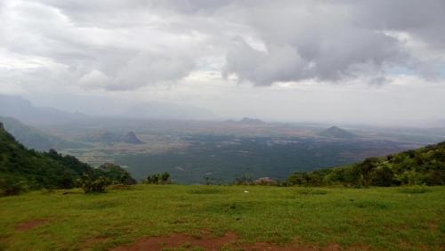 a view from the top of a hill with mountains in the background at Shawn Dale Homestay in Ramakkalmedu