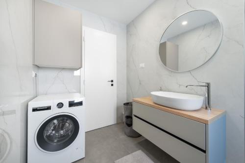 a bathroom with a washing machine and a sink at Villa Rocco in Srima