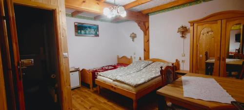 a small bedroom with a bed and a table at Letni Domek , Ogrzewany, z bilardem in Ruciane-Nida